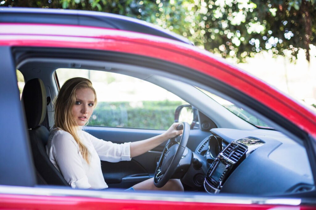 Side view of a young woman sitting inside a car
